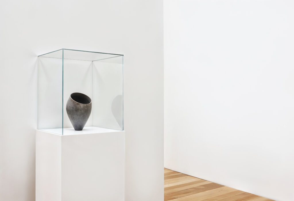 Imagen de un museo con una escultura en una vitrina de vidrio