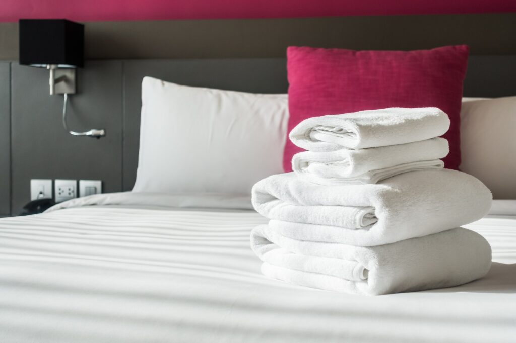 Imagen interior de un hotel con unas toallas sobre la cama